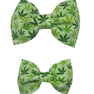 Two green 420 Cannabis Leaf Dog Bowties are displayed, each with a playful pattern of dark and light green cannabis leaves. Ideal for fun occasions like 420, the top bow tie is larger than the bottom one, both set against a light green background.