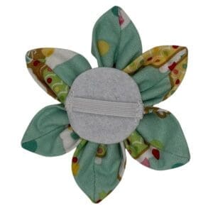 Green fabric flower accessory with elastic band.